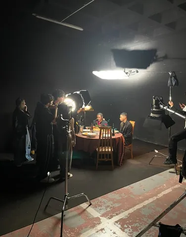 Equipo de rodaje alrededor de la mesa iluminada