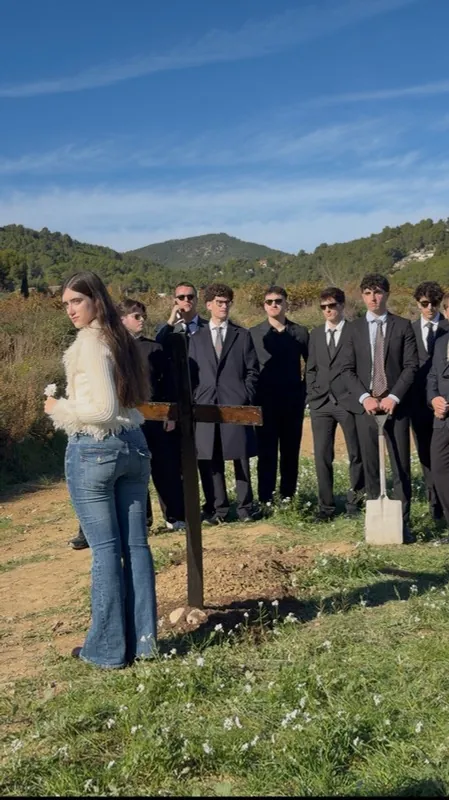 La protagonista con el cortejo vestido de negro en el campo
