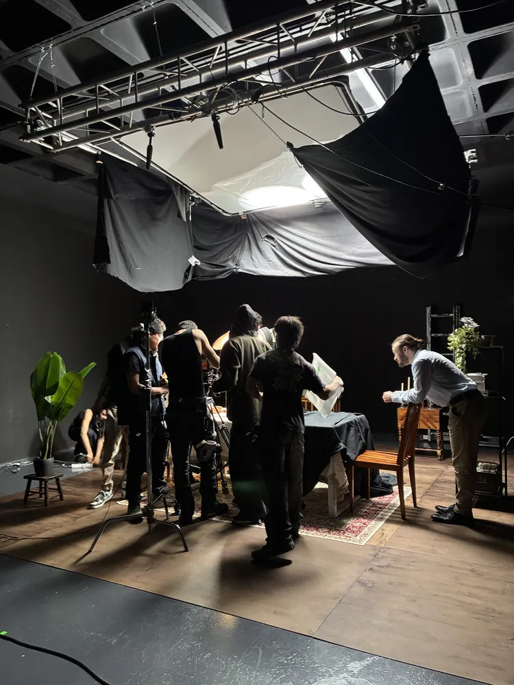 Equipo preparando un plano junto a la mesa del decorado