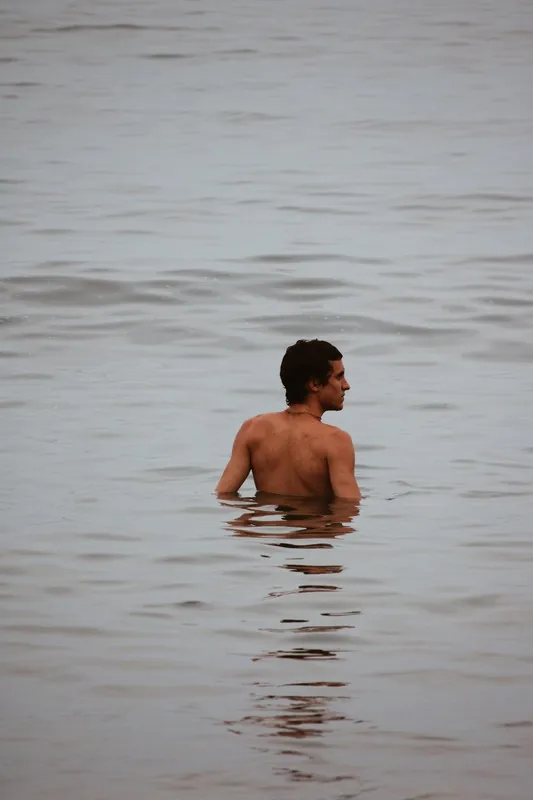 Hombre bañándose en el mar en calma
