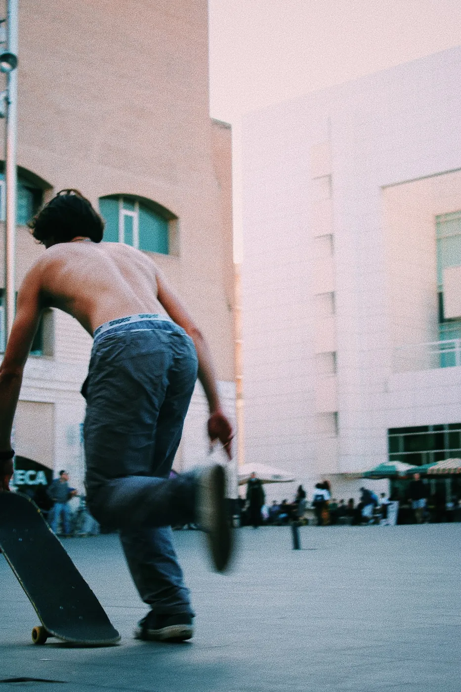 Skater de espaldas impulsándose en la plaza del MACBA