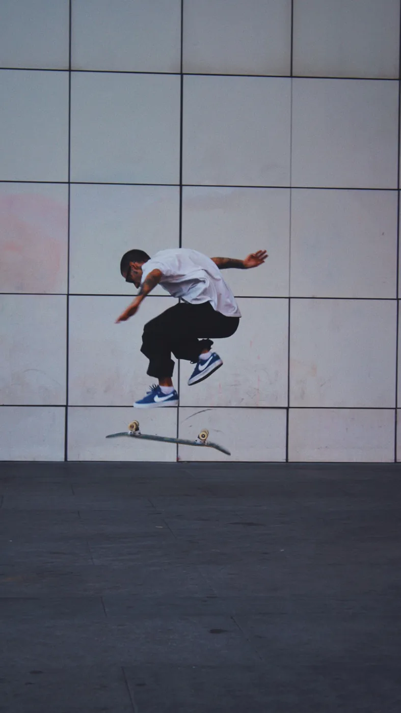 Skater saltando frente a una pared de paneles blancos