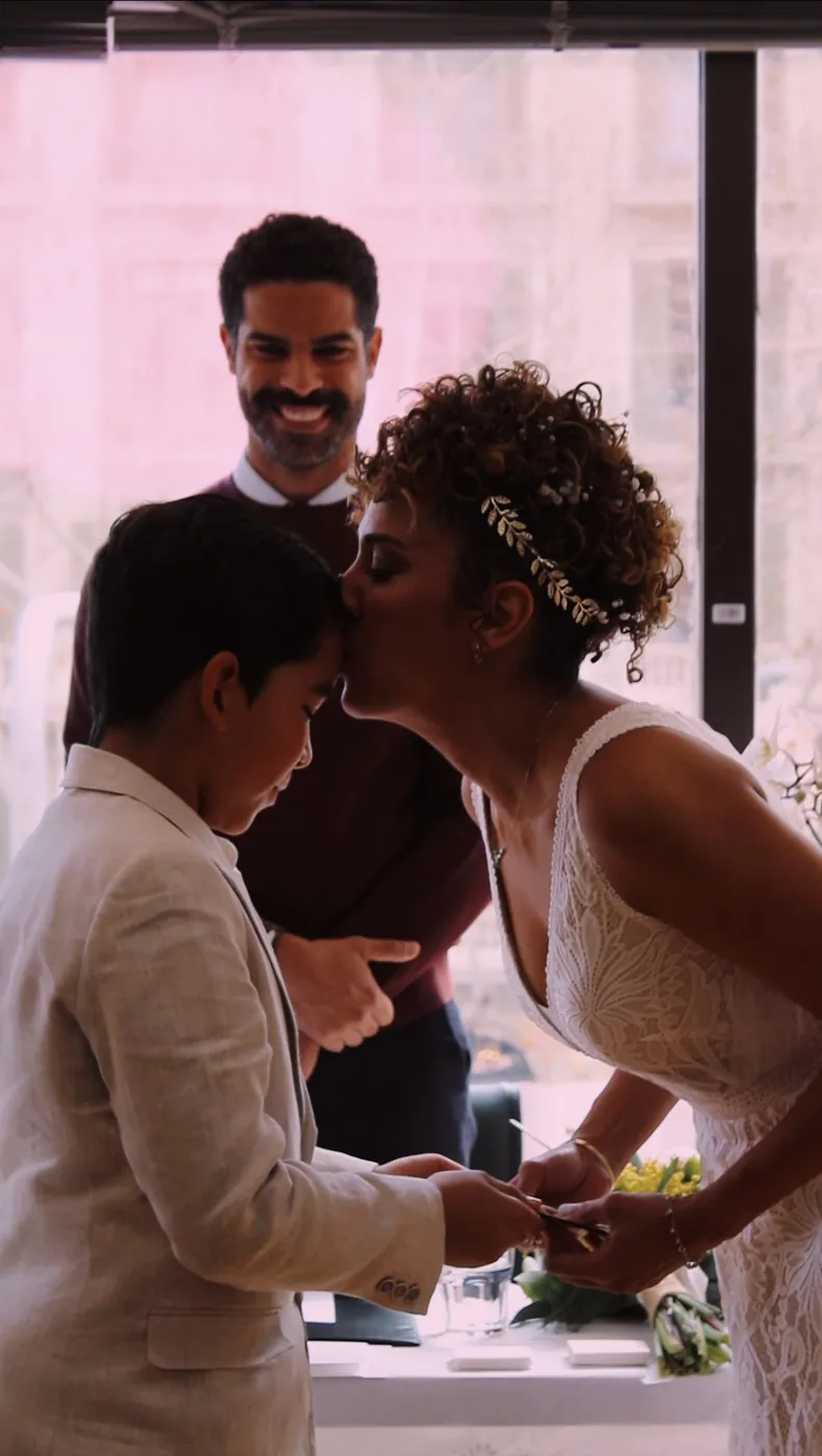 La novia besa en la frente a un niño durante la ceremonia
