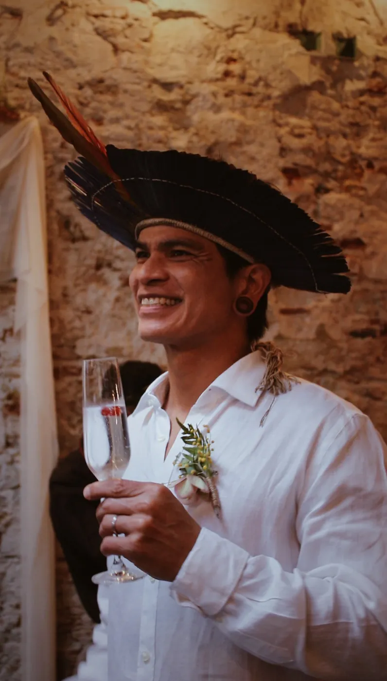 Novio con tocado de plumas brindando