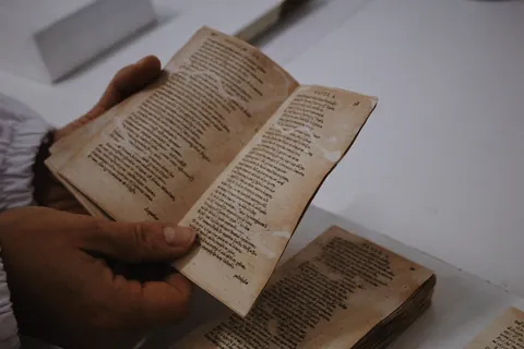 Manos sosteniendo un libro antiguo en un taller de restauración