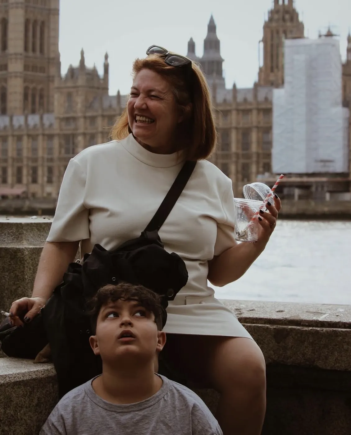 Mujer riendo junto a un niño frente al Parlamento de Londres
