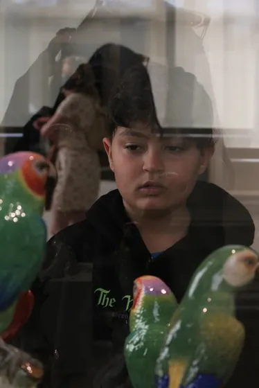 Niño con sudadera negra rodeado de figuras de colores